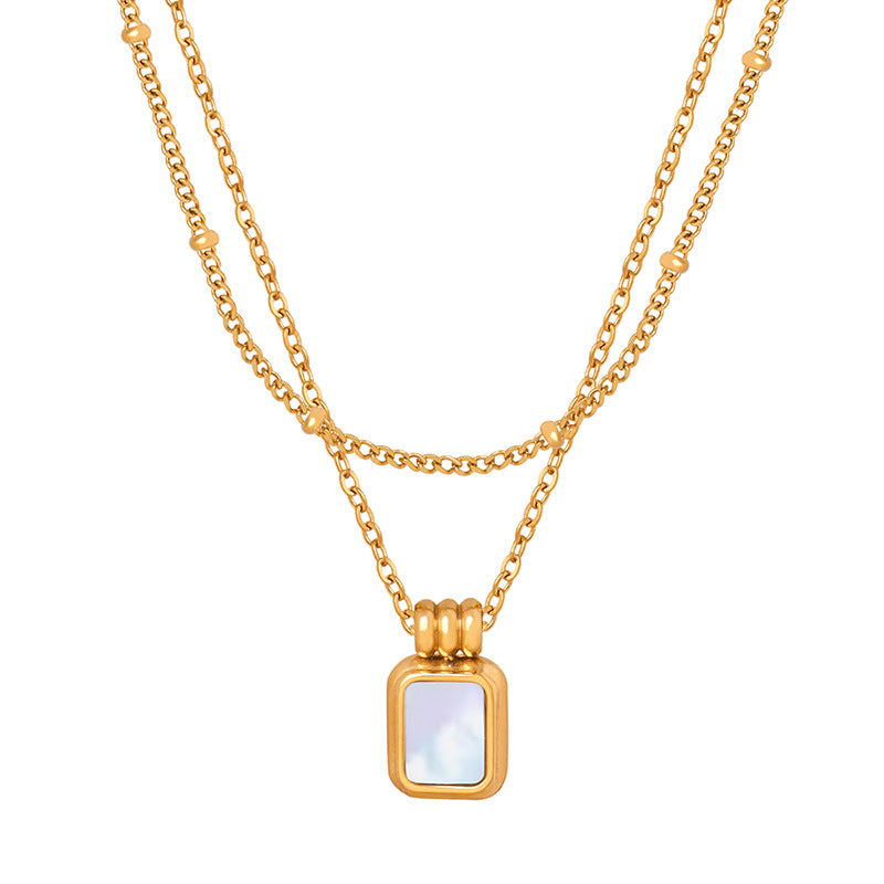 A gold-colored necklace with white shape