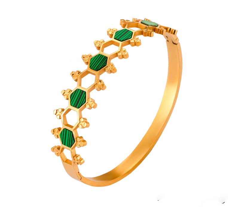 A gold-colored bracelet featuring a series of green emerald beads along its length.