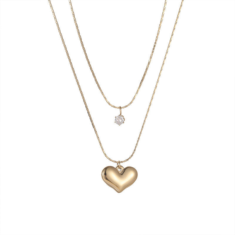 A gold-colored necklace with a pendant