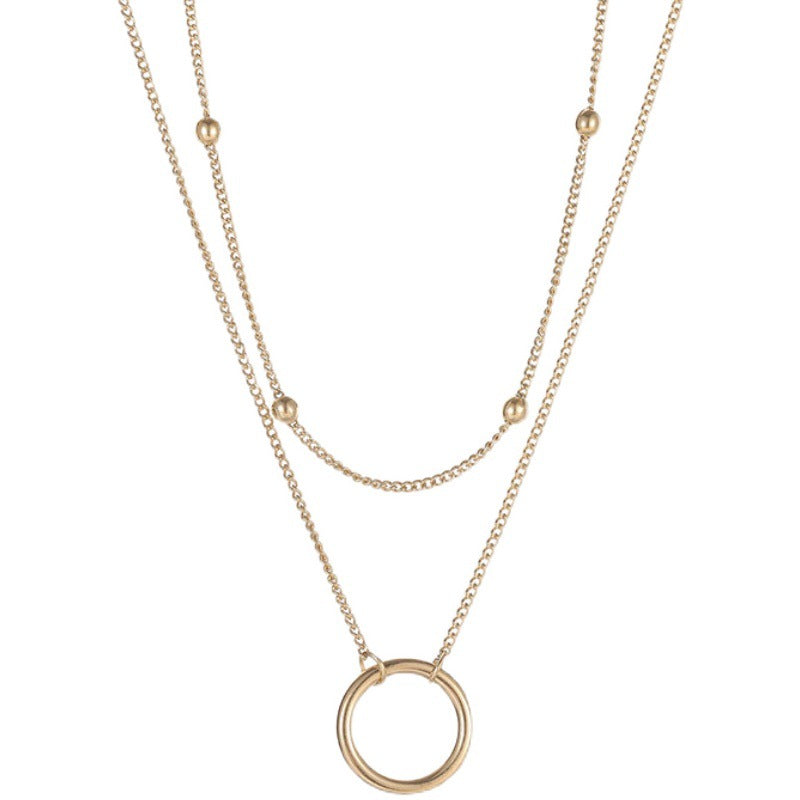 A gold-colored necklace with a round pendant .