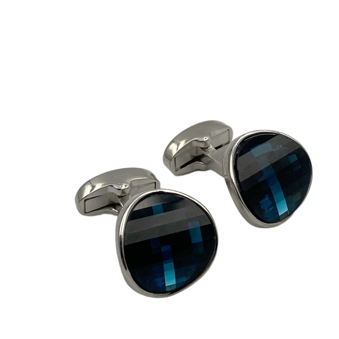 A pair of silver-colored cufflinks with dark blue crystal inserts.