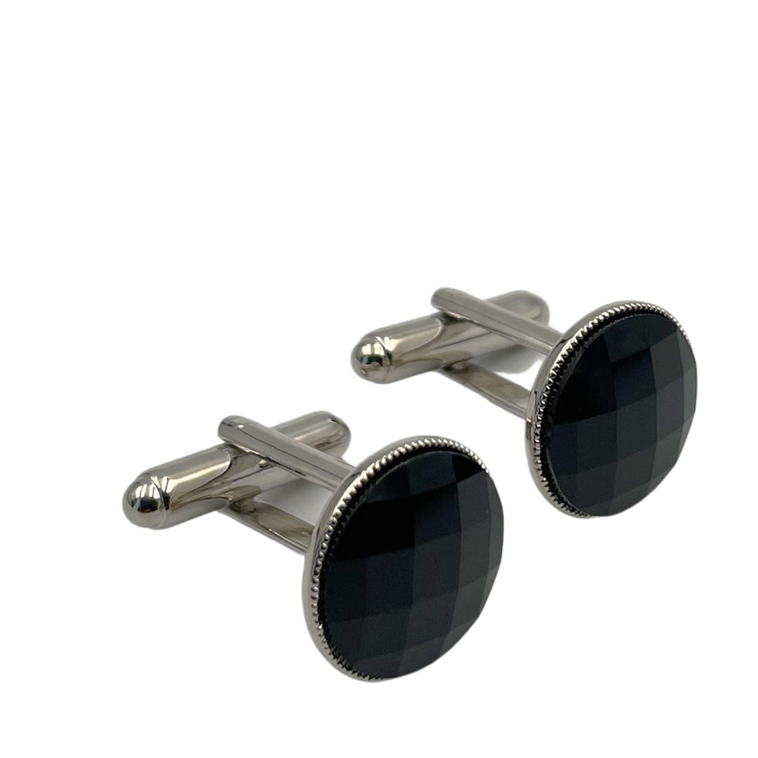 A pair of silver and black swarovski crystal cufflinks with a round shape and beveled edges.